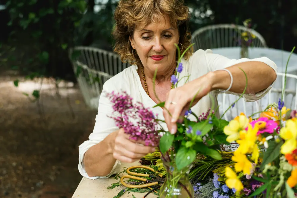 Una mujer de mediana edad avanzada arreglando flores.